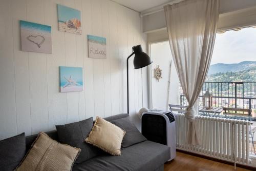 a living room with a couch and a large window at Lugano Boat Apartment in Lugano