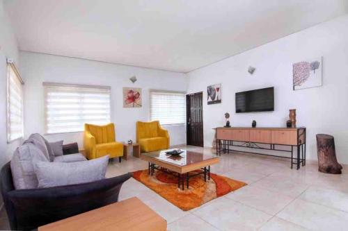 ein Wohnzimmer mit Sofa und Klavier in der Unterkunft Daffodil Suite in Lagos