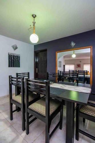 ein Esszimmer mit einem Tisch, Stühlen und einem Spiegel in der Unterkunft Daffodil Suite in Lagos