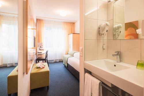 a hotel room with a sink and a bedroom at Hotel Seehof Superior in Walenstadt