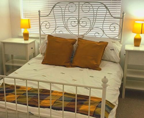 a white bed with a metal headboard and pillows at 3 bedroom village house 