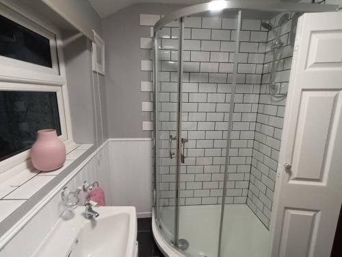 a bathroom with a sink and a glass shower at 3 bedroom village house in Cosby