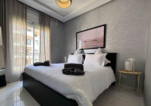 Appartement agréable en plein coeur de Marrakech pour 2 à 4 Personnes في مراكش: غرفة نوم بسرير كبير مع شراشف بيضاء