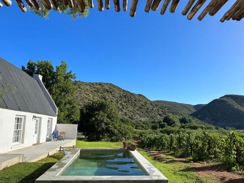a swimming pool in a yard next to a house at De Kombuys in Oudtshoorn