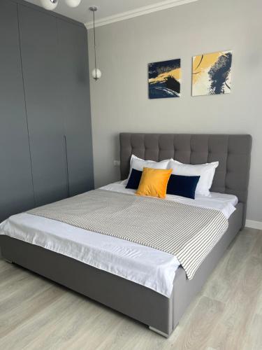 a bedroom with a large bed with orange and blue pillows at Аренда квартиры 2 in Prigorodnyy