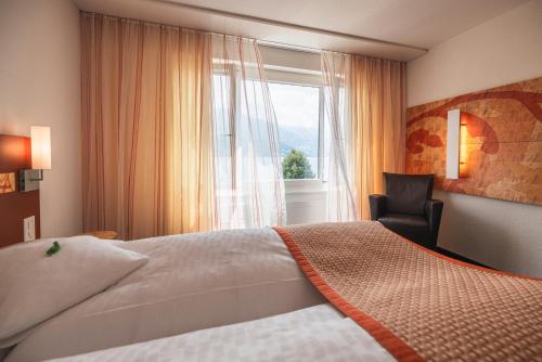 sypialnia z dużym łóżkiem i oknem w obiekcie Hotel Seehof Superior w mieście Walenstadt