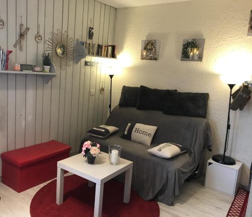 Chaleureux Logement - 4 Couchages في Uvernet: غرفة نوم بسرير وطاولة عليها ورد