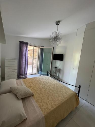 a bedroom with a large bed and a chandelier at Villa Concetta in Torre del Lago Puccini