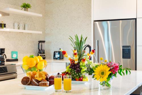 a kitchen with a counter with fruit and juice at H2O LifeStyle Resort in Long Bay Hills