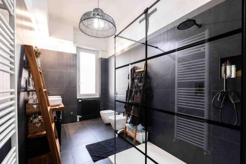 Baño negro con aseo y lavamanos en Apartment Design 5 Stelle en Novara