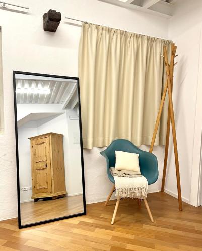 a mirror in a room with a chair and a dresser at Streiter Rooms in Bolzano