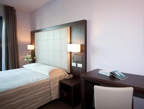 a hotel room with a bed and a desk at Hotel Porto Azzurro in Sirmione