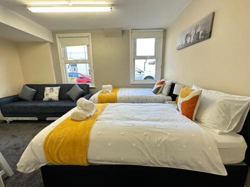 a bedroom with two beds and a couch at Comfy City Stay in Colchester