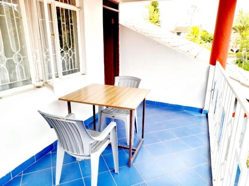 a balcony with a wooden table and two chairs at Milimani Comfort in Kisumu