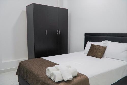 麥德林的住宿－Apartamentos, Colores del Estadio - Laureles.，一间卧室配有一张床,上面有两条毛巾