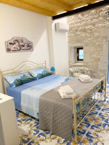 a bedroom with two beds and a stone wall at IL RIFUGIO BAROCCO in Modica