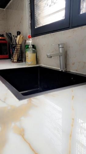 a kitchen counter with a sink and aaucet at Mlandege apartment in Ngambo