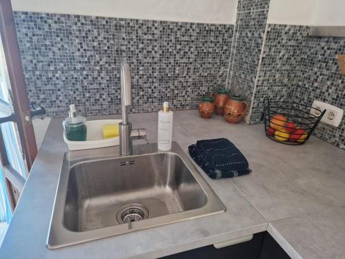 Casa De La Familia - Appartement في بازا: طاولة مطبخ مع حوض في مطبخ