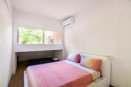 ein kleines Schlafzimmer mit einem Bett und einem Fenster in der Unterkunft Punta ala Fronte Mare in Punta Ala
