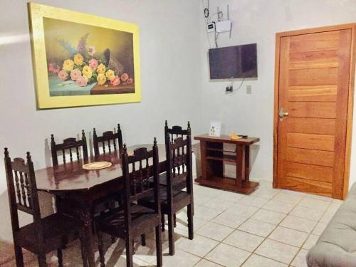 a dining room with a table and a painting of flowers at Casa Brisas in Luis Correia