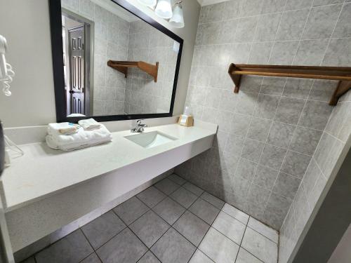 a bathroom with a sink and a mirror at Days Inn by Wyndham Slidell in Slidell