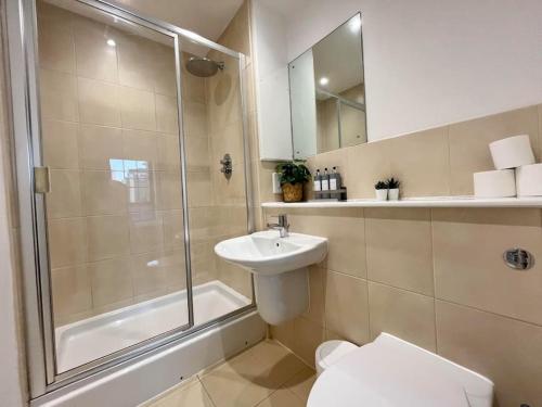 a bathroom with a shower and a toilet and a sink at Spacious 2 Bedroom Apartment with Parking in Nottingham