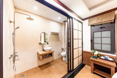 uma casa de banho com um chuveiro e um WC. em Khai Ngoc Hotel em Da Lat