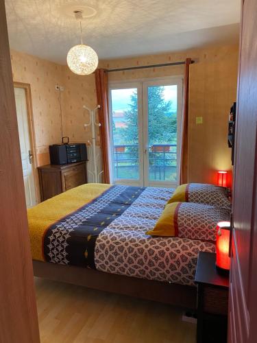 1 dormitorio con cama y ventana en VILLA des CHEMINS, en Cussac-sur-Loire