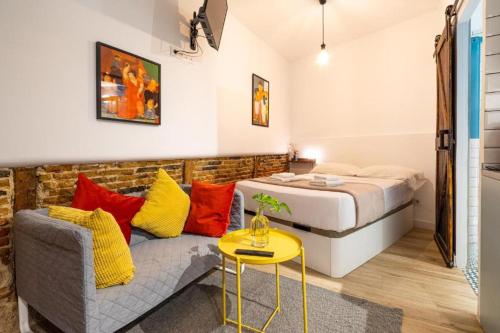 een slaapkamer met een bed, een bank en een tafel bij El Rastro Historic center in Madrid