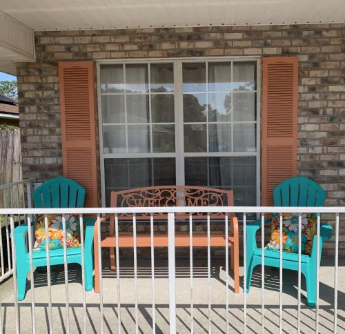 two chairs and a table on a porch at D's Florida-Alabama Vacation Home Sleeps 14 Guests in Pensacola