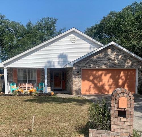 a house with a brown garage at D's Florida-Alabama Vacation Home Sleeps 14 Guests in Pensacola