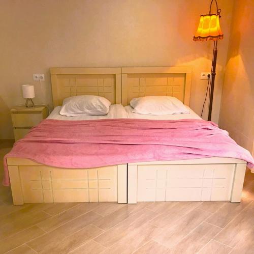 a bedroom with a large bed with a pink blanket at Apartment 19 in Kutaisi