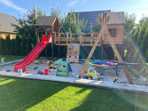 a play yard with a playground with a slide at Miło Cię widzieć in Łeba