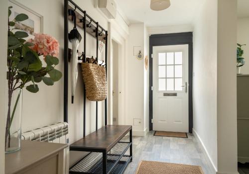 a hallway with a table and a door at The Portpatrick Pad - A cosy 3 bed cottage, w. sea views & garden office in Portpatrick