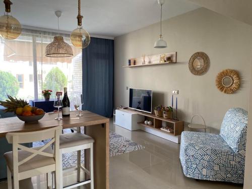 a living room with a table and chairs and a television at Villa Lavanda Golf in Balchik