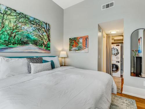 a bedroom with a white bed and a tv at The Haywood in Savannah
