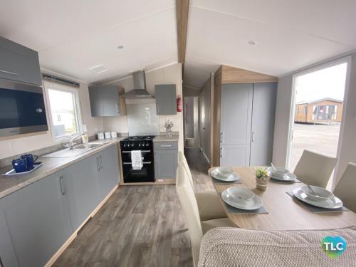 a kitchen and dining room with a table and chairs at Caravan on Fantastic site in Dunbar