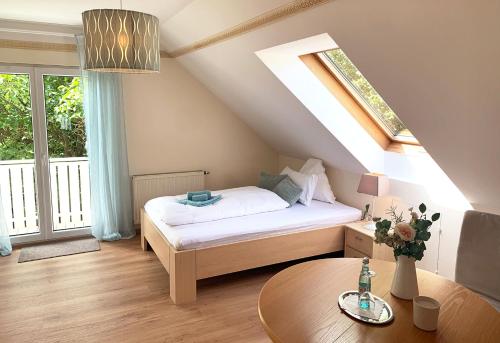 a small bedroom with a bed and a table at Apartmenthaus Oberndorf 