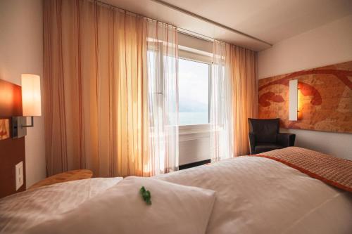 a hotel room with a bed and a window at Hotel Seehof Superior in Walenstadt