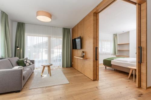 シュラートミンクにあるAparthotel Ursprungのリビングルーム(ソファ、ベッド付)、ベッドルーム1室が備わります。