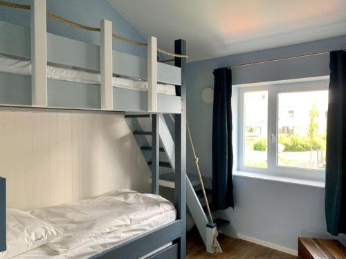 a bedroom with a bunk bed and a window at Ferienwohnung-Seepferdchen-Finnlandring in Timmendorfer Strand