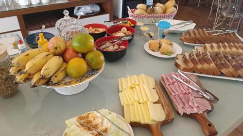 a table topped with lots of cheese and fruit at Belo quinto Styles pousada in Brotas