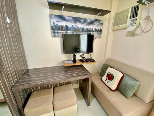 a small room with a wooden table and a television at Nice location in the persimmon condo in Cebu City