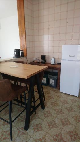 a kitchen with a wooden table and a white refrigerator at Torre Colimena Appartamento Ralf in Torre Colimena