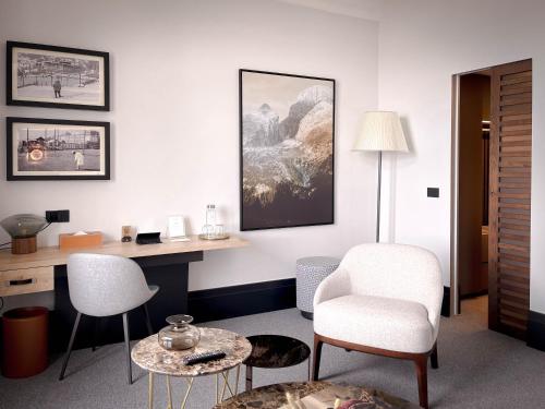 a room with a desk and two chairs and a table at Villars Palace in Villars-sur-Ollon