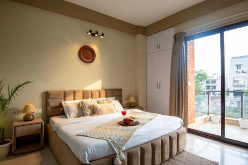 a bedroom with a large bed and a large window at Serviced Apartment near Medanta by BedChambers in Gurgaon