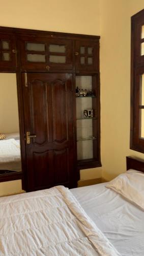 a bedroom with a wooden cabinet and a white bed at PINETOP RESORT in Khanpur