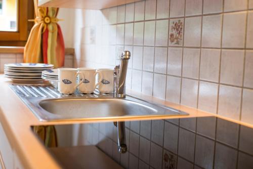 a kitchen sink with two mugs on it at Appartementhaus zur Post in Bad Gastein