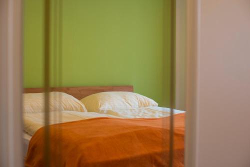 a bed in a room with green walls at AlpinSpa zur Post Apartment - Bergbahn im Sommer 2025 inklusive in Bad Gastein