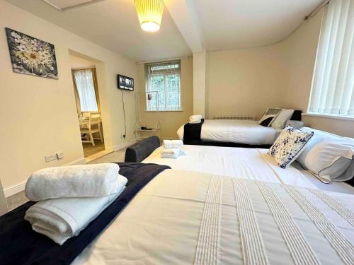 a large bedroom with two beds with white sheets at City Stay in Colchester